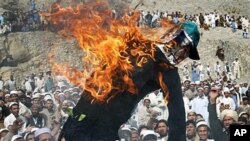 Effigy of the American pastor Terry Jones is seen burning during a demonstration in Shinwar, Nangarhar province, east of Kabul, Afghanistan, after protests erupted in Afghanistan again Monday against the Florida pastor's burning of the Quran, April 4, 201