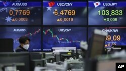 A currency trader watches monitors at the foreign exchange dealing room of the KEB Hana Bank headquarters in Seoul, South Korea, Jan. 8, 2021.