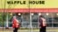 Emergency workers walk outside a Waffle House restaurant Sunday, April 22, 2018, in Nashville, Tenn. At least four people died after a gunman opened fire at the restaurant early Sunday.
