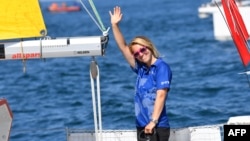 FILE - British skipper Susie Goodall waves from the helm of her boat "DHL Starlight" as she leaves Les Sables d'Olonne Harbor, July 1, 2018, at the start of the solo around-the-world "Golden Globe Race." 