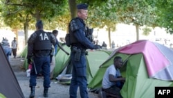 Les migrants et les réfugiés sont évacués de leur camp par la police anti-émeute CRS française sur la place Daviais à Nantes, dans l'ouest de la France, le 23 juillet 2018.