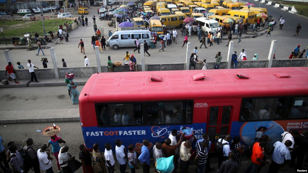 Warga antre naik bus di distrik Obalende di Lagos, Nigeria, tempat ojek dilarang beroperasi di pusat-pusat kota. (Reuters/Akintunde Akinleye)
