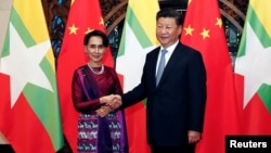 Myanmar State Counselor Aung San Suu Kyi, left, and Chinese Premier Xi Jinping pose for the media before a meeting in Beijing, Aug. 19, 2016.