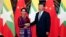 Myanmar State Counselor Aung San Suu Kyi, left, and Chinese Premier Xi Jinping pose for the media before a meeting in Beijing, Aug. 19, 2016.