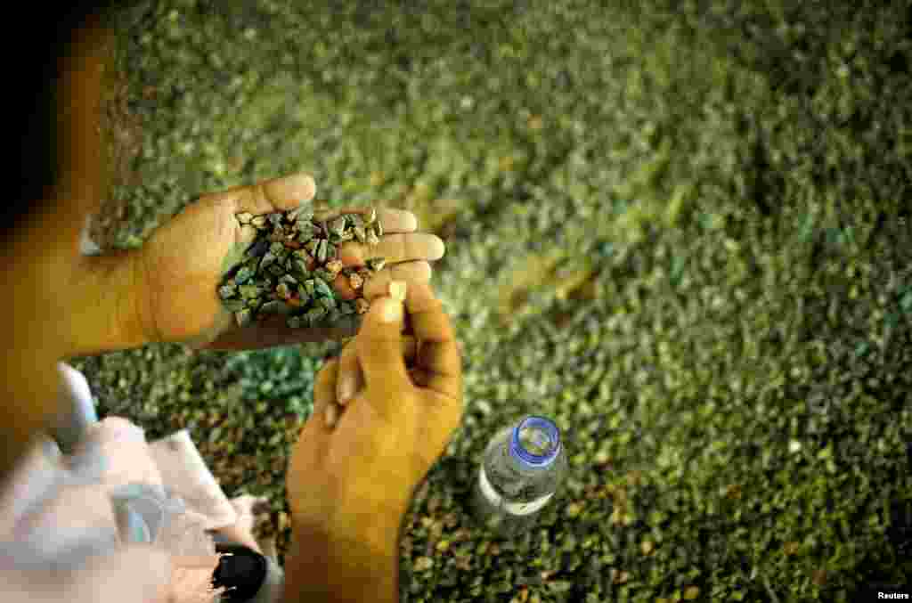 شیطان کو مارنے کے لئے ایک حاجی کنکریاں جمع کر رہا ہے