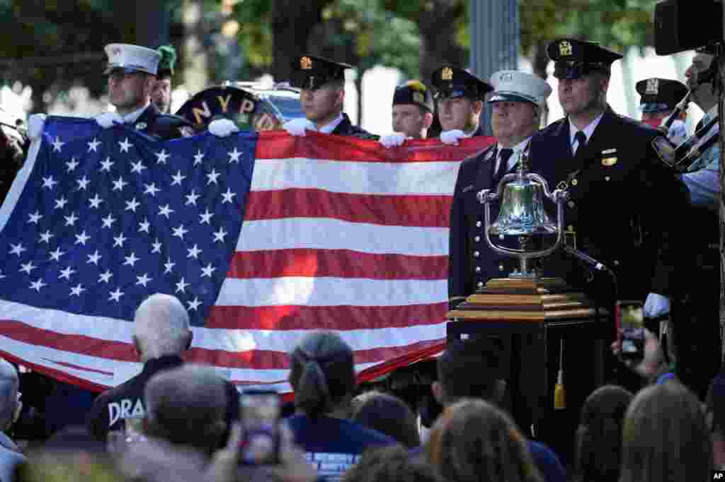 A New York Police Department honor guard holds an American flag during a 9/11 commemoration ceremony at Ground Zero, in New York, Sept. 11, 2024.