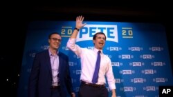 FILE - Democratic presidential candidate Pete Buttigieg (R), and husband, Chasten Glezman, acknowledge supporters after speaking at a campaign event in West Hollywood, Calif., May 9, 2019. 
