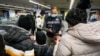 A Carabinieri policeman checks the green health pass of public transportation passengers in Rome, Italy, Dec. 6, 2021, on the first day a super green health pass went into effect. 