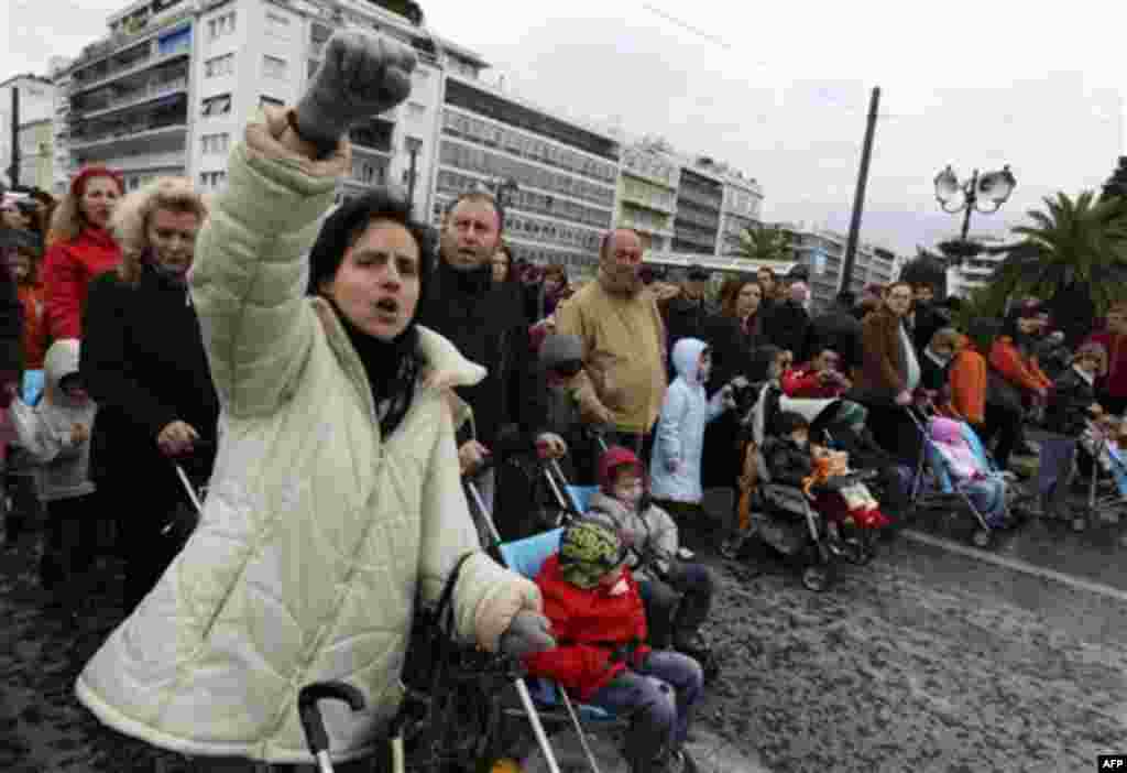 Demonstrators from the Greek Association of Large Families chant anti-government slogans during a protest in central Athens, on Wednesday, Dec. 15, 2010. Hundreds of protesters clashed with riot police across central Athens Wednesday, smashing cars and hu