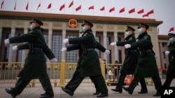 Chinese soldiers march past the Great Hall of the People during a preparatory session of the National People's Congress in Beijing, March 4, 2024.