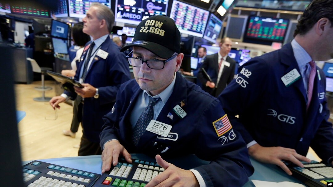 FILE - A trader wears a "Dow 22,000" hat as he works at his post on the floor of the New York Stock Exchange, Wednesday, Aug. 2, 2017. 