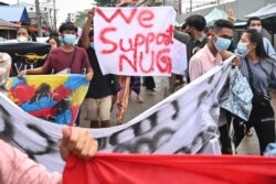 FILE - Protesters hold a banner in support of the National Unity Government (NUG) as they take part in a demonstration against the military coup, in Yangon, July 7, 2021.