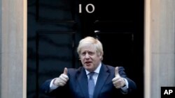 Britain's Prime Minister Boris Johnson shows thumbs up before he applauds on the doorstep of 10 Downing Street in London during the weekly "Clap for our Carers," April 30, 2020. 