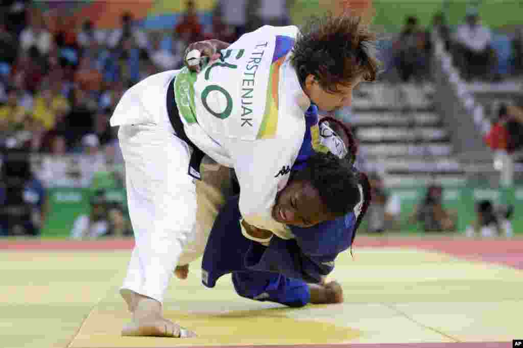 Tina Trstenjak dari Slovenia (atas) bertanding melawan Clarisse Agbegnenou dari Perancis dalam pertandingan merebut medali emas dari cabang olahraga yudo nomor 61 kilogram putri (9/8) di Rio de Janeiro. (AP/Gregory Bull)