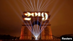 Arc de Triomphe bermandikan cahaya selama perayaan Tahun Baru di Paris, Perancis, 1 Januari 2019 (foto: Reuters/Christian Hartmann)