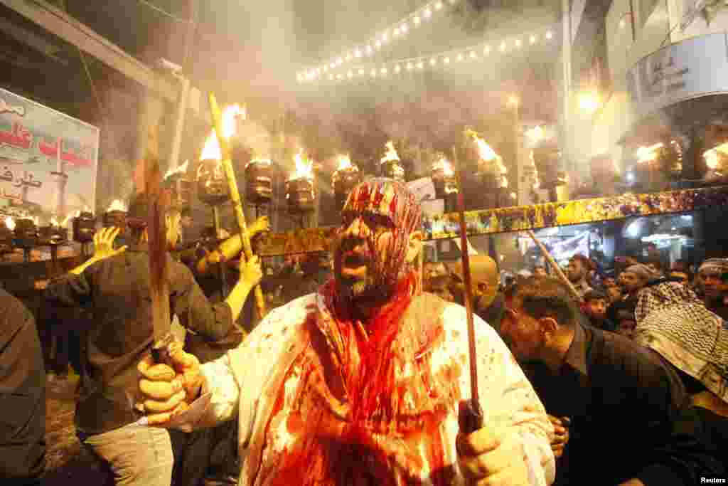 Seorang pria Syiah melukai dahinya dengan pedang dalam festival agama Ashura di Najaf, Irak (11/11).