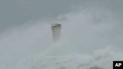 Surging waves hit against the breakwater and a lighthouse as Typhoon Hagibis approaches at a port in the town of Kiho, Mie prefecture, central Japan, Oct. 12, 2019. 