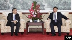 This Macau Government handout picture released on December 19, 2014 shows Chinese President Xi Jinping (R) meeting with Macau Chief Executive Fernando Chui at the San Chok Un Guesthouse in Macau, Dec. 19, 2014. 