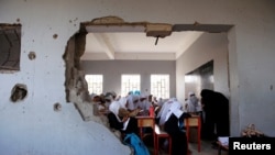 FILE - Girls attend a class at their school, damaged by a recent Saudi-led airstrike, in the Red Sea port city of Hodeida, Yemen, Oct. 24, 2017.