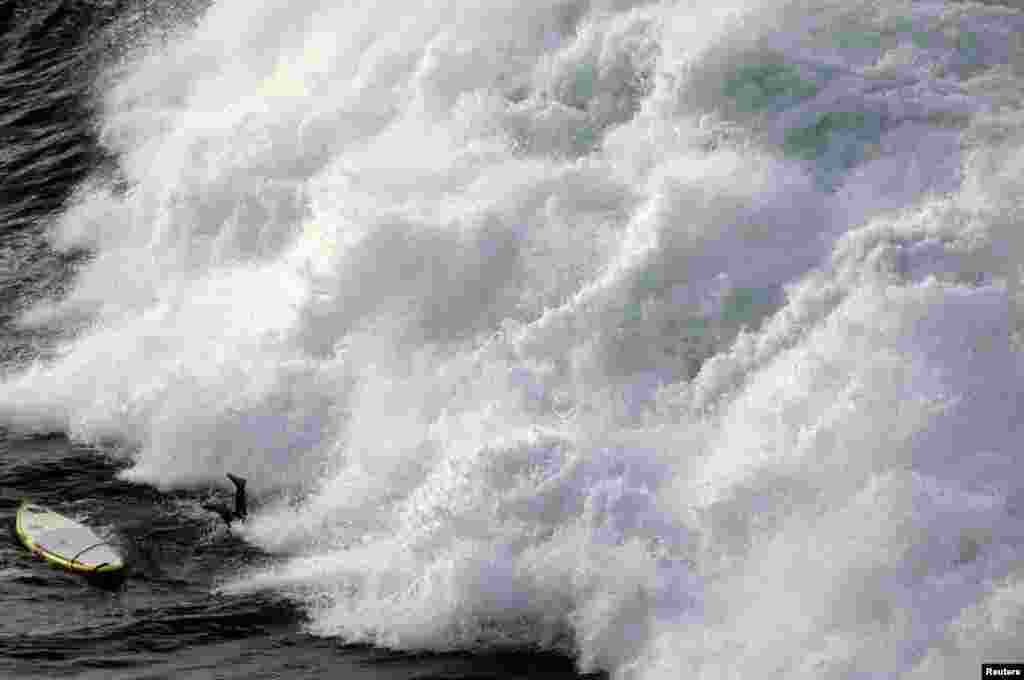 A paddle board surfer dives under a large wave at a place known by locals as &#39;Winkie Pop&#39;, located near Manly Beach in Sydney, Australia.