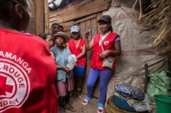 FILE - Red Cross volunteers talk to villagers about the plague outbreak, 30 miles west of Antananarivo, Madagascar, Oct. 16, 2017.