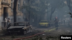 A rescuer walks along cars damaged during a Russian drone and missile strike in Lviv, Ukraine, Sept. 4, 2024.