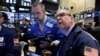 FILE - Traders Kevin Lodewick, left, and Richard Cohen work on the floor of the New York Stock Exchange, Sept. 26, 2016.