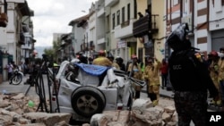 Un policía junto a un automóvil aplastado por los escombros después de que un terremoto sacudiera Cuenca, Ecuador, el sábado 18 de marzo de 2023. (AP Foto/Xavier Caivinagua)