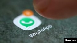 FILE - The WhatsApp app logo is seen on a smartphone in this picture illustration. 