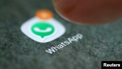 FILE - The WhatsApp app logo is seen on a smartphone in this picture illustration. 