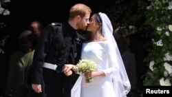 Prince Harry and Meghan, the Duchess of Sussex, kiss as they leave St George's Chapel at Windsor Castle after their wedding, May 19, 2018.