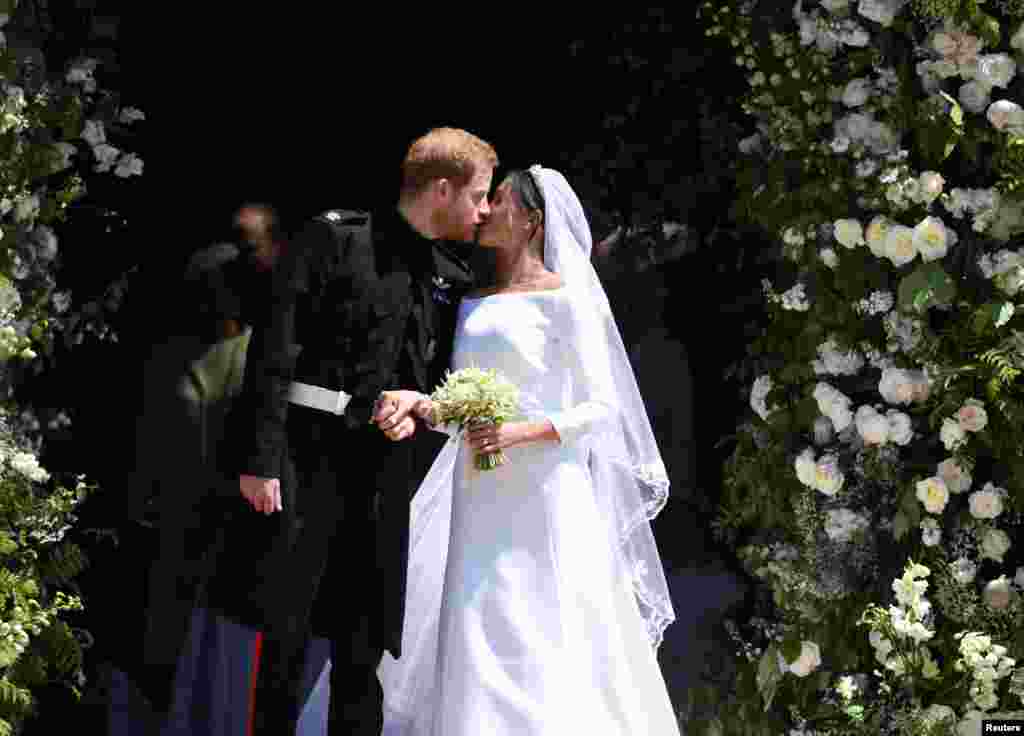 5월 19일 영국 해리 왕자가 메간 마클이 런던 인근 윈저에서&nbsp;결혼식을 마친 후 세인트 조지 교회를 떠나기 전 입맞춤을 하고 있다. 신랑인 해리 왕자는 영국 왕실의 일원이며, 신부인 메건 마클은 미국의 전직 배우이다.&nbsp;