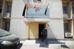 A man walks out of a building bearing a sign saying, "The Bahraini Society Against Normalization With Zionist Enemy," in Manama, Bahrain, Sept. 12, 2020.