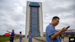 Workers gather near a building at the Wenchang Space Launch Site in Wenchang in southern China's Hainan province, Nov. 23, 2020. 