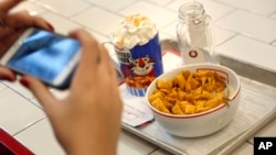 A woman takes a picture of her breakfast at Kellogg's Cafe NYC in New York, Dec. 14, 2017. 