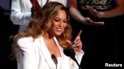 FILE - Beyonce reacts after winning the entertainer of the year award, Los Angeles, California, March 30, 2019.
