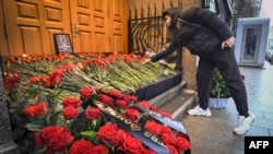 Seorang pria menaruh bunga di depan kedutaan besar Azerbaijan di Moskow, Rusia, pada 26 Desember 2024, dalam rangka memberikan penghormatan kepada para korban kecelakaan pesawat Azerbaijan Airlines. (AFP/Alexander Nemenov)