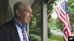 In this Friday, July 12, 2013 photo, retired U.S. Navy Capt. Thomas Hudner, who was awarded the Medal of Honor by President Truman, poses on the porch at his home in Concord, Mass. 