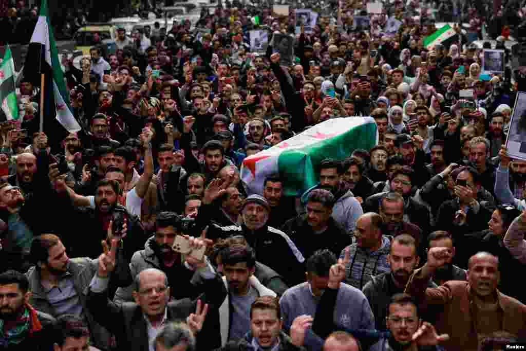 People carry the body of Syrian activist Mazen al-Hamada, who according to Syrian activists was found dead in a prison in Damascus, after rebels seized the capital and ousted President Bashar al-Assad, in Damascus.