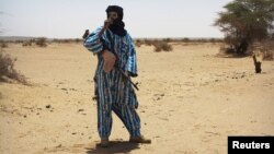 Un combattant du groupe séparatiste Touareg MNLA débout devant l’assemblée locale à Kidal, Mali, 23 juin 2013.