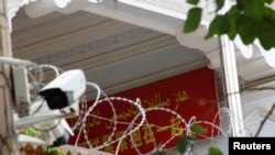 A propaganda banner and a security camera are placed on the walls of a mosque in the Old City in Kashgar, Xinjiang Uighur Autonomous Region, China, Sept. 6, 2018. 