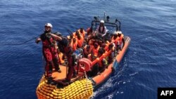 FILE: An inflatable dinghy belonging to the Ocean Viking rescue ship, operated by French NGOs SOS Mediterranee and Medecins sans Frontieres (MSF), transports migrants rescued from their dinghy during an operation in the Mediterranean Sea, Aug. 12, 2019. 