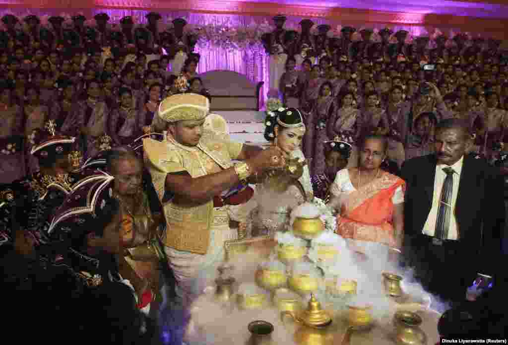 Sri Lankan couple Nisansala and Nalin pour water into small pots during their wedding ceremony