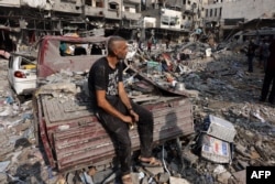 Seorang pria duduk terpekur di tengah kehancuran menyusul serangan Israel di kamp Al-Shatee di Kota Gaza pada 28 Oktober 2023. (Foto: AFP)