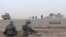 This frame grab from video provided Wednesday, Nov 8, 2017 by the government-controlled Syrian Central Military Media, shows Syrian pro-government troops taking up positions during fighting with insurgents on the Iraq-Syria border. The Britain-based Syrian Observatory for Human Rights, said that Islamic State militants have withdrawn from their last stronghold following a government offensive and that government forces and allied troops, including Iraqi fighters are combing Boukamal, a strategic town on the border with Iraq, Thursday.