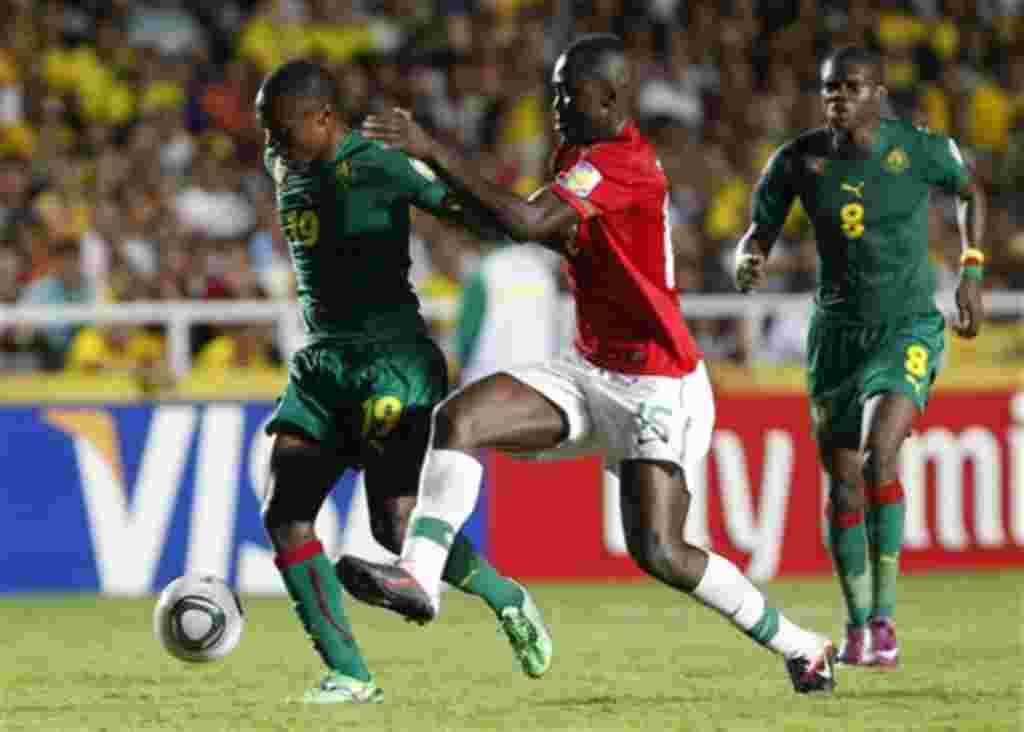Challenged by Portugal's Danilo, center, Cameroon's Christ Mbondi, left, plays the ball during a U-20 World Cup group B soccer match in Cali, Colombia, Tuesday, Aug. 2, 2011. At right, Cameroon's Emmanuel Mbongo. (AP Photo/Fernando Vergara)