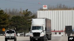 FILE - A truck leaves the Tyson Foods pork plant in Perry, Iowa, April 22, 2020. The plant is the site of the state's largest outbreak of the coronavirus; 730 workers tested positive.