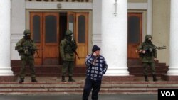 Pasukan bersenjata terlihat berpatroli di bandara Simferopol di semenanjung Krimea, Ukraina (28/2).