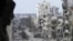 Damaged buildings line a deserted street in the besieged area of Homs in Syria on January 9, 2014.