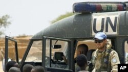 A United Nations Mission in the Central African Republic and Chad (MINURCAT) peacekeeper is seen with Sudanese children from the Oure Cassoni refugee camp in Bahaï, Eastern Chad, 16 Oct 2009
